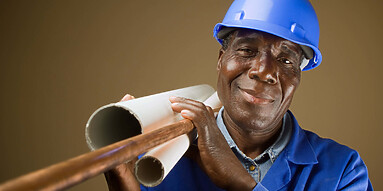 Senior South African or American plumber with pipes