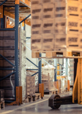 Man operating forklift in warehouse safely.