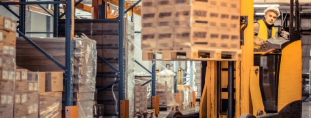 Man operating forklift in warehouse safely.