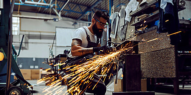 A worker using the grinder for metal processing