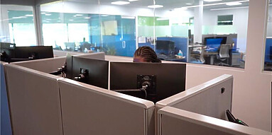 Inside the office space, employees are working at computers.